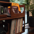 A close up of the forward facing flip bins displaying the art of a vinyl record in the irving vinyl record storage and turntable stand furnture