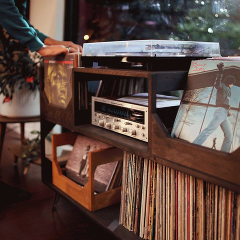 A record collector hunts for what he is playing next in the flip forward record storage bins on the dark walnut Irving Turntable Station